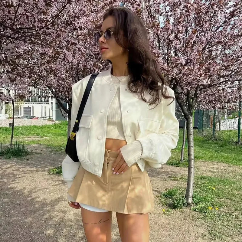 Stylish white bomber jacket for women with buttons, long sleeves, and a cropped design. Perfect for autumn and winter.